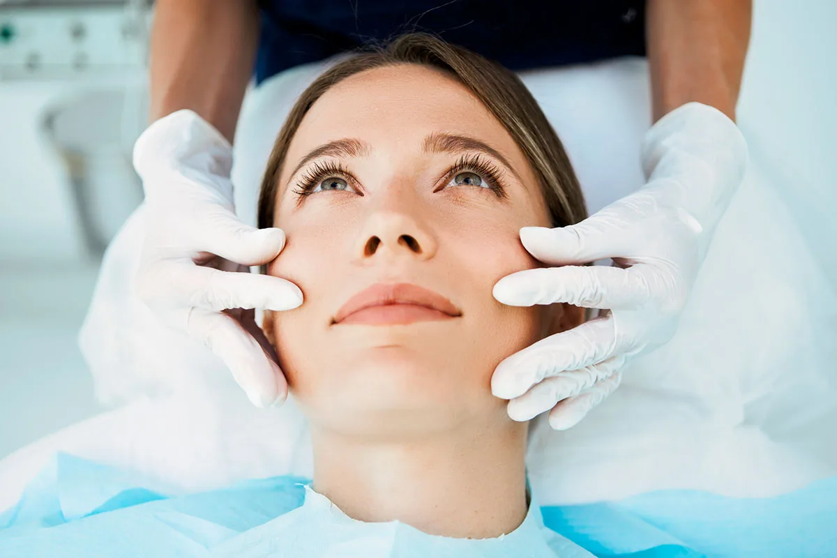 a woman having her face examined before a liquid face lift treatment